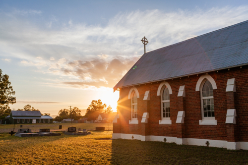 sunrise light behind chapel in country village of Broke on summer morning - Australian Stock Image