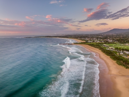 Sunrise looking south along Bulli Beach to Woonona rock pool - Australian Stock Image