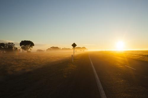 Sunrise on a  regional highway with silhouette road side sign