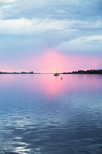 sunrise over river with moored boats, vertical