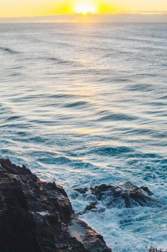 Sunrising over ocean and cliffs