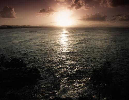 Sunset Byron Bay with surfers - Australian Stock Image