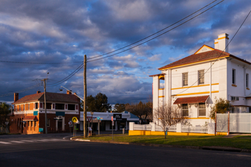 Sunset light illuminating architecture of old building along main street of country town of Merriwa - Australian Stock Image
