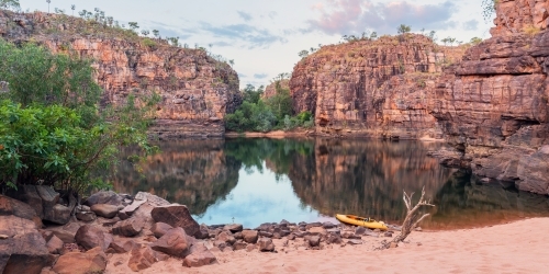 Sunset light over rocky cliff and still pool of outback Nitmiluk Gorge