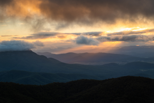 Sunset rays over scenic mountain landscape - Australian Stock Image