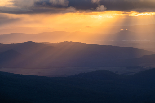 Sunset rays over scenic mountain landscape - Australian Stock Image