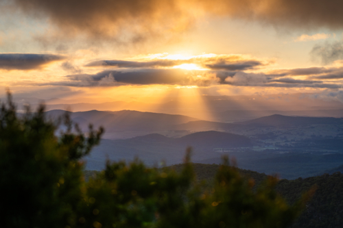Sunset rays over scenic mountain landscape - Australian Stock Image