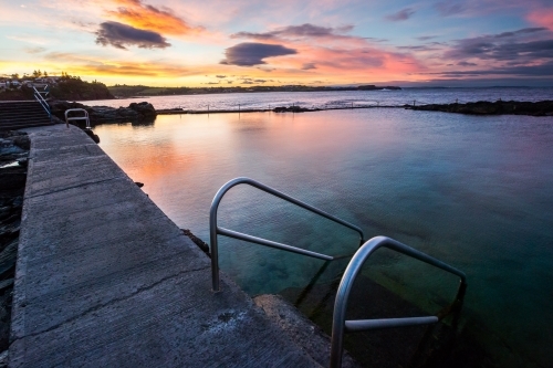 Sunset reflecting in an ocean swimming pool - Australian Stock Image