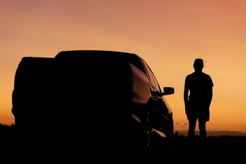 Sunset silhouette of man and car - Australian Stock Image