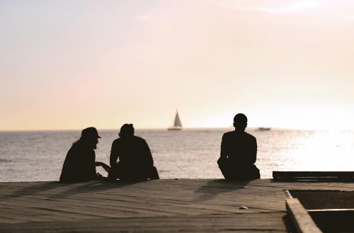 Sunset silhouette of people on a jetty - Australian Stock Image
