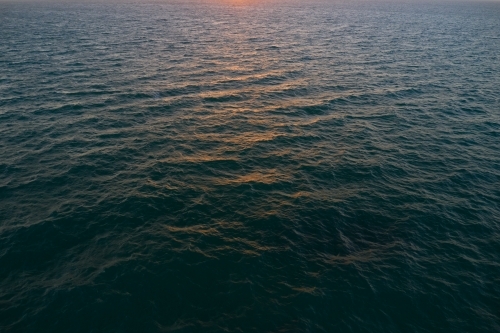 Sunset sunlight reflecting of the ocean's surface - Australian Stock Image