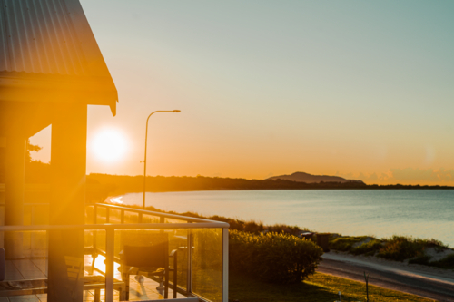 Sunset view of the beach and horizon from a balcony - Australian Stock Image