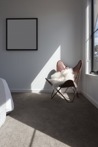 Sunshine highlight on a leather chair in a master bedroom - Australian Stock Image