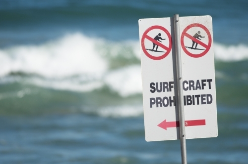 Surf craft prohibited on the beach with waves in the background