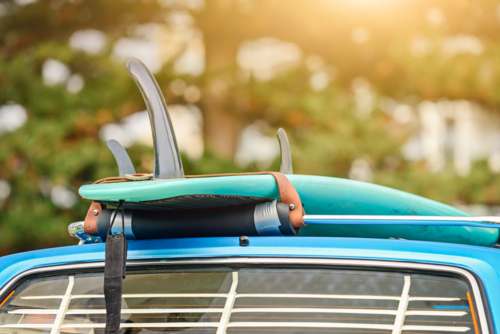 Surfboard on roof rack of vintage car - Australian Stock Image