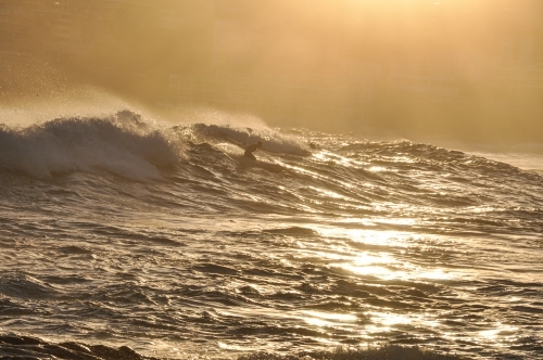 Surfer on paddleboard in big surf - Australian Stock Image
