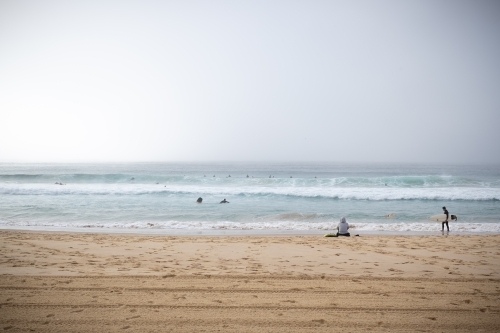 surfers enjoy the waves and the dense fog