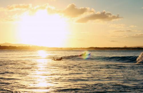 Surfers Paddling at Sunset
