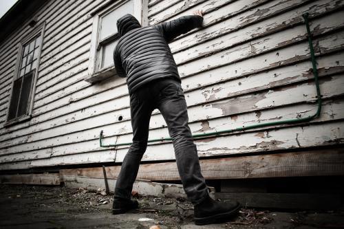Suspected criminal looking into the window from the laneway - Australian Stock Image