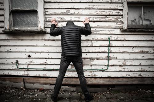 Suspected criminal with his hands against the wall - Australian Stock Image