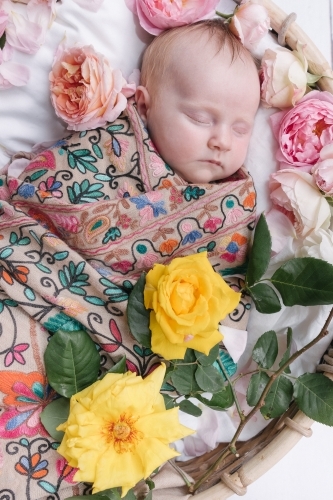 Sweet sleeping baby with flowers.