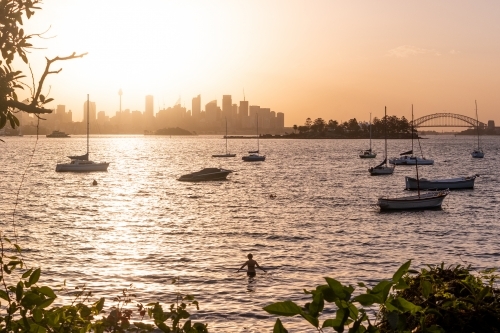Swimmer enjoys the sunset over Sydney city - Australian Stock Image
