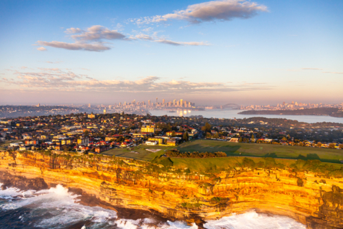 Sydney cliffs with Harbour Bridge and skyline at sunset - Australian Stock Image