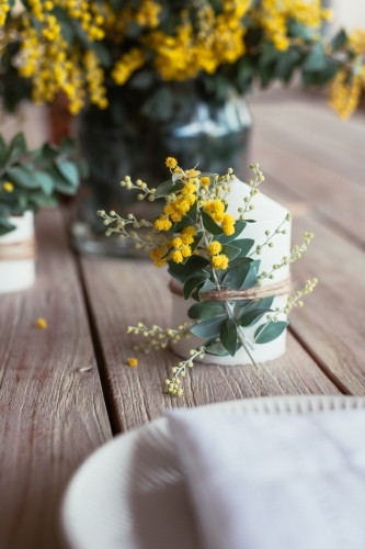 table decor with wattle on candle - Australian Stock Image