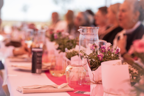 Table setting with flowers, and women in the background - Australian Stock Image