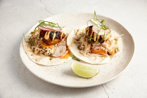 Tacos dish with lemon slice on plate - Australian Stock Image