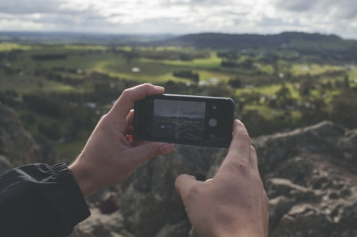 Taking photos of a valley with a smartphone - Australian Stock Image