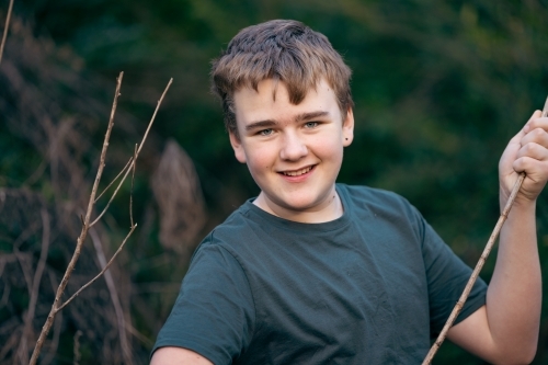 Teen boy in nature with happy smile - Australian Stock Image