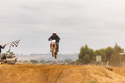 Teen boy riding motorbike at motocross track meet - Australian Stock Image