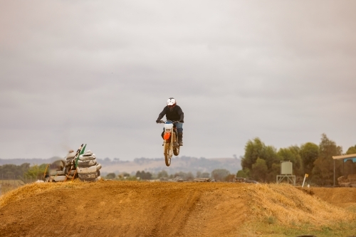 Teen boy riding motorbike at motocross track meet - Australian Stock Image