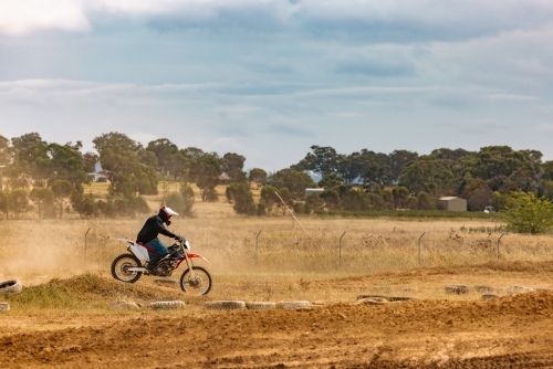 Teen boy riding motorbike at motocross track meet - Australian Stock Image