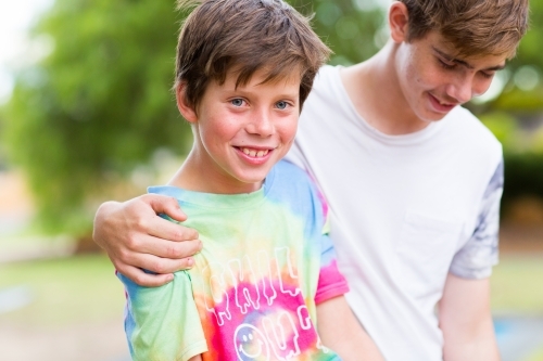 Teen boy with arm around his little brother - Australian Stock Image