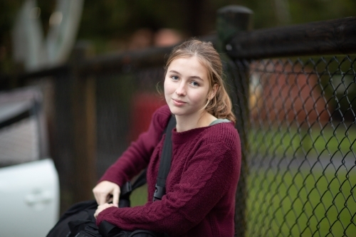 Teen girl carrying sports bag near sports field - Australian Stock Image