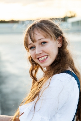 Teen girl looking over her shoulder smiling - Australian Stock Image