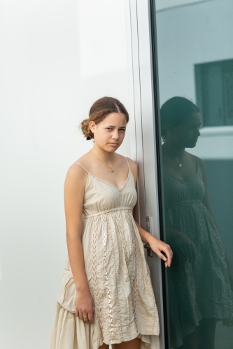 teen girl standing near closed door - Australian Stock Image