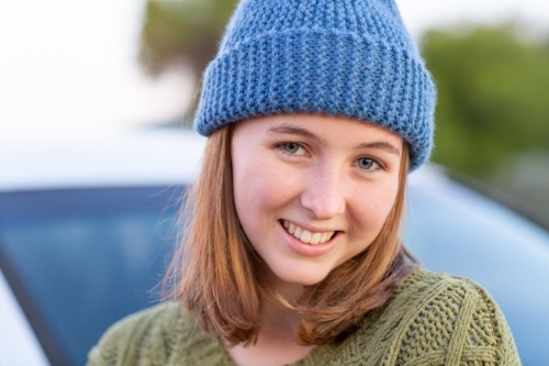 teen girl wearing hand-knitted beanie smiling - Australian Stock Image