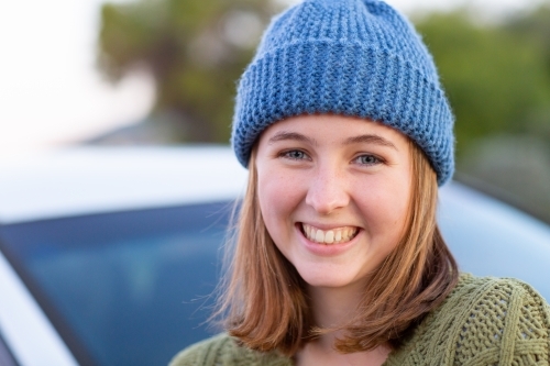teen girl wearing hand-knitted beanie smiling - Australian Stock Image