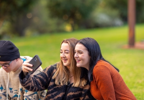 teen girls taking a selfie outdoors