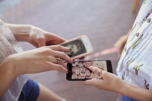 Teen girls using mobile phones - Australian Stock Image