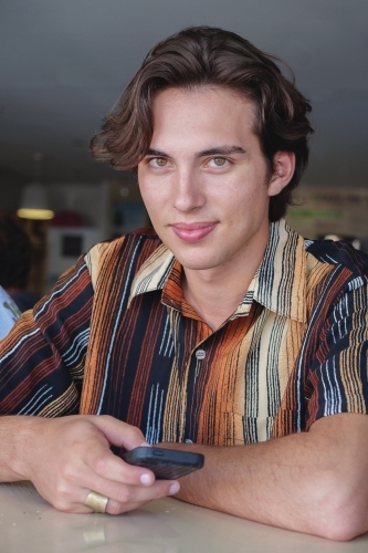 young adult boy using mobile phone - Australian Stock Image