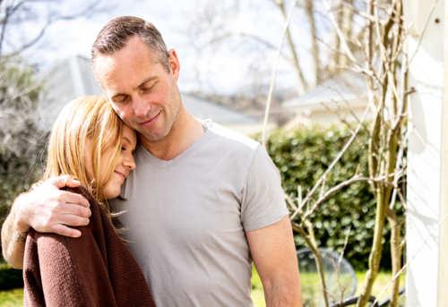 Teenage daughter head leaning on fathers chest - Australian Stock Image