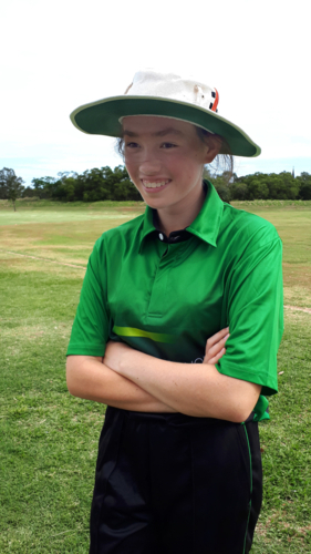 Teenage female cricket players smiling with arms crossed standing on a cricket field - Australian Stock Image