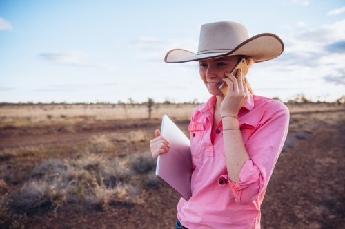 Teenage Female with smart phone and computer on the farm - Australian Stock Image