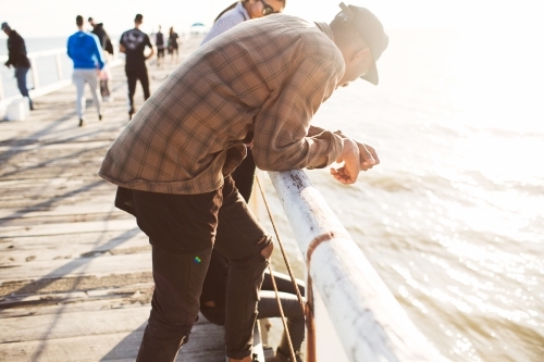 Teenage friends relaxing on a jetty - Australian Stock Image