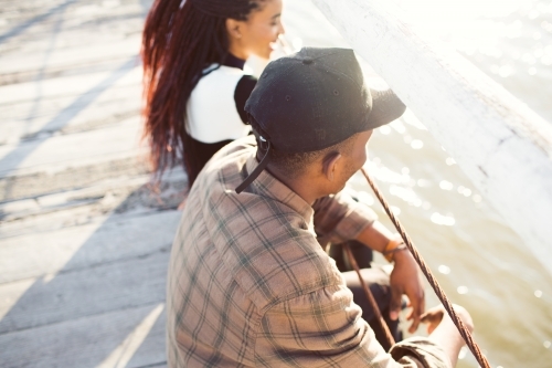 Teenage friends relaxing on a jetty - Australian Stock Image