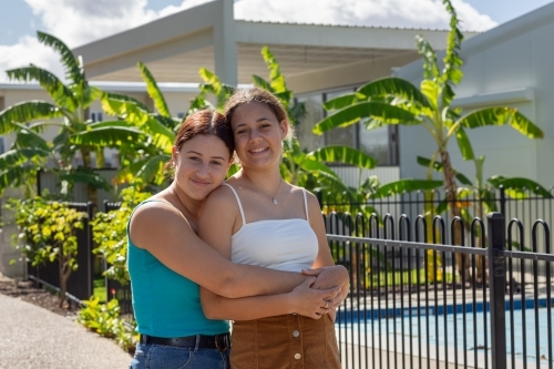 teenage friends with arms around each other - Australian Stock Image